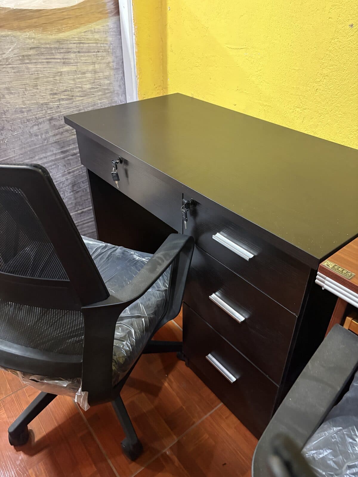 Escritorio negro con cajonera y chapas con llave